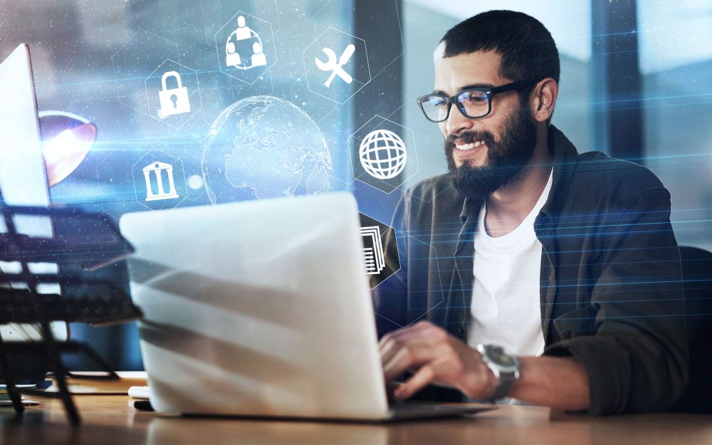 Homem usando notebook com ícones de cibersegurança em interface holográfica, representando venda consultiva de proteção digital.