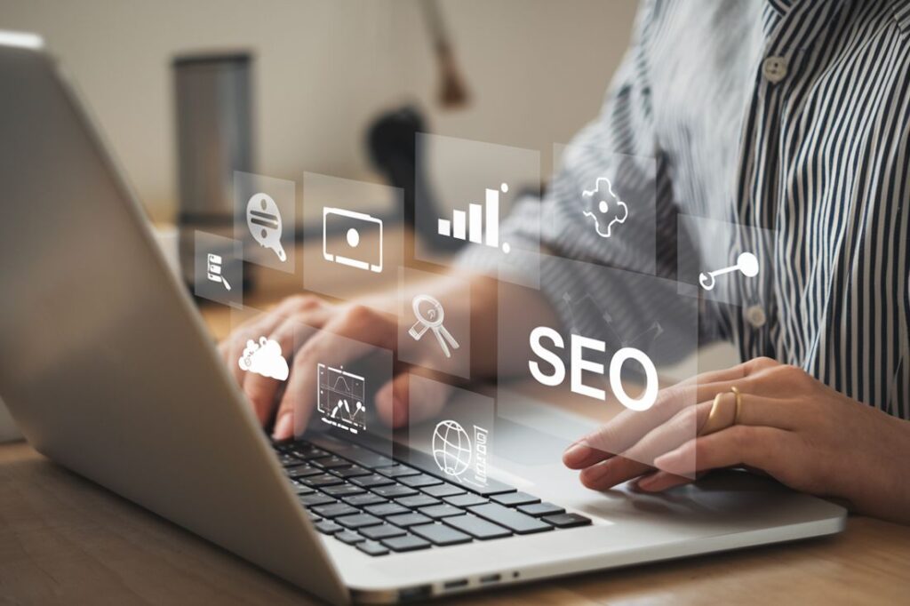 Pessoa digitando em notebook com ícones de SEO em interface holográfica, representando otimização para buscas orgânicas.