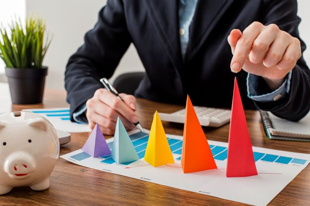 Pessoa analisa gráfico com cones coloridos representando crescimento e etapas do funil de marketing.