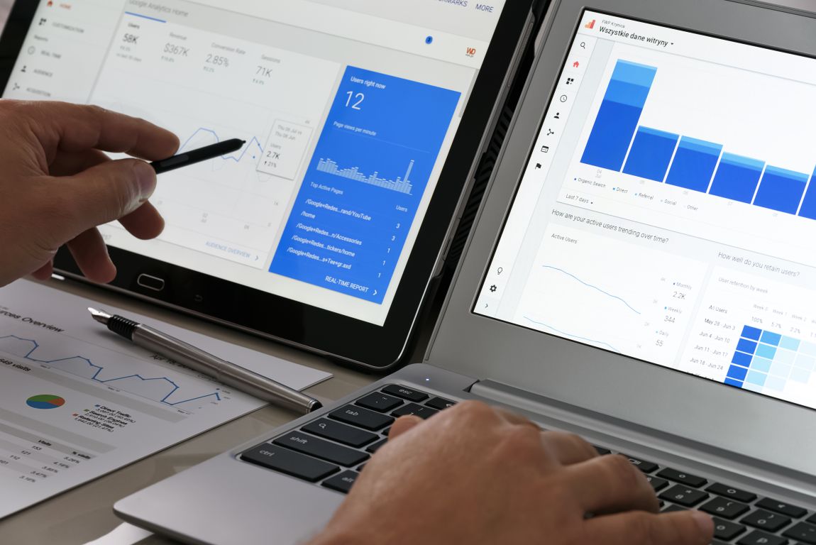 Pessoa analisa dashboards com gráficos e relatórios de métricas Google Ads em notebook e tablet.